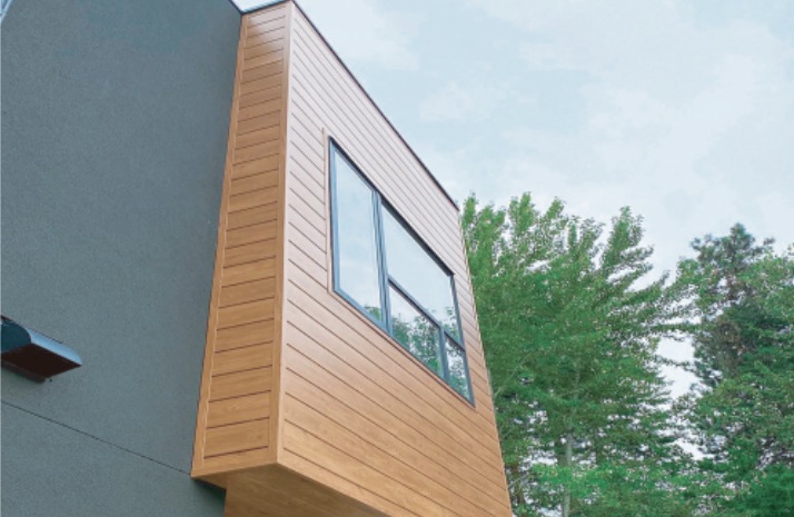 Close view of wood-look facade panels on an exterior wall