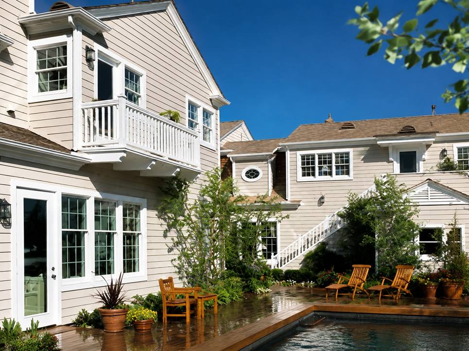 Residential Exterior Application Light neutral vinyl siding used across a residential exterior and outdoor living area by Home Plus Materials